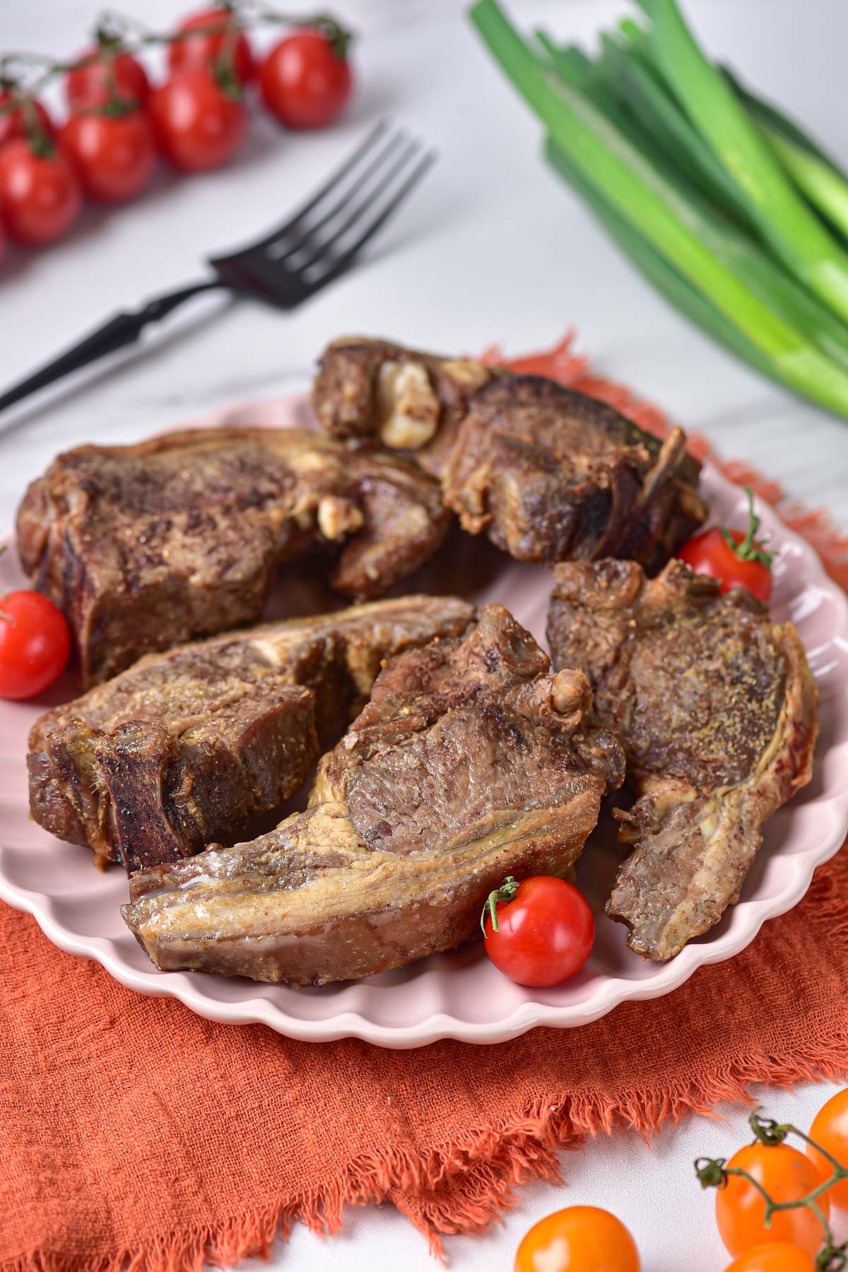The completed air fryer lamb chops served on a white plate