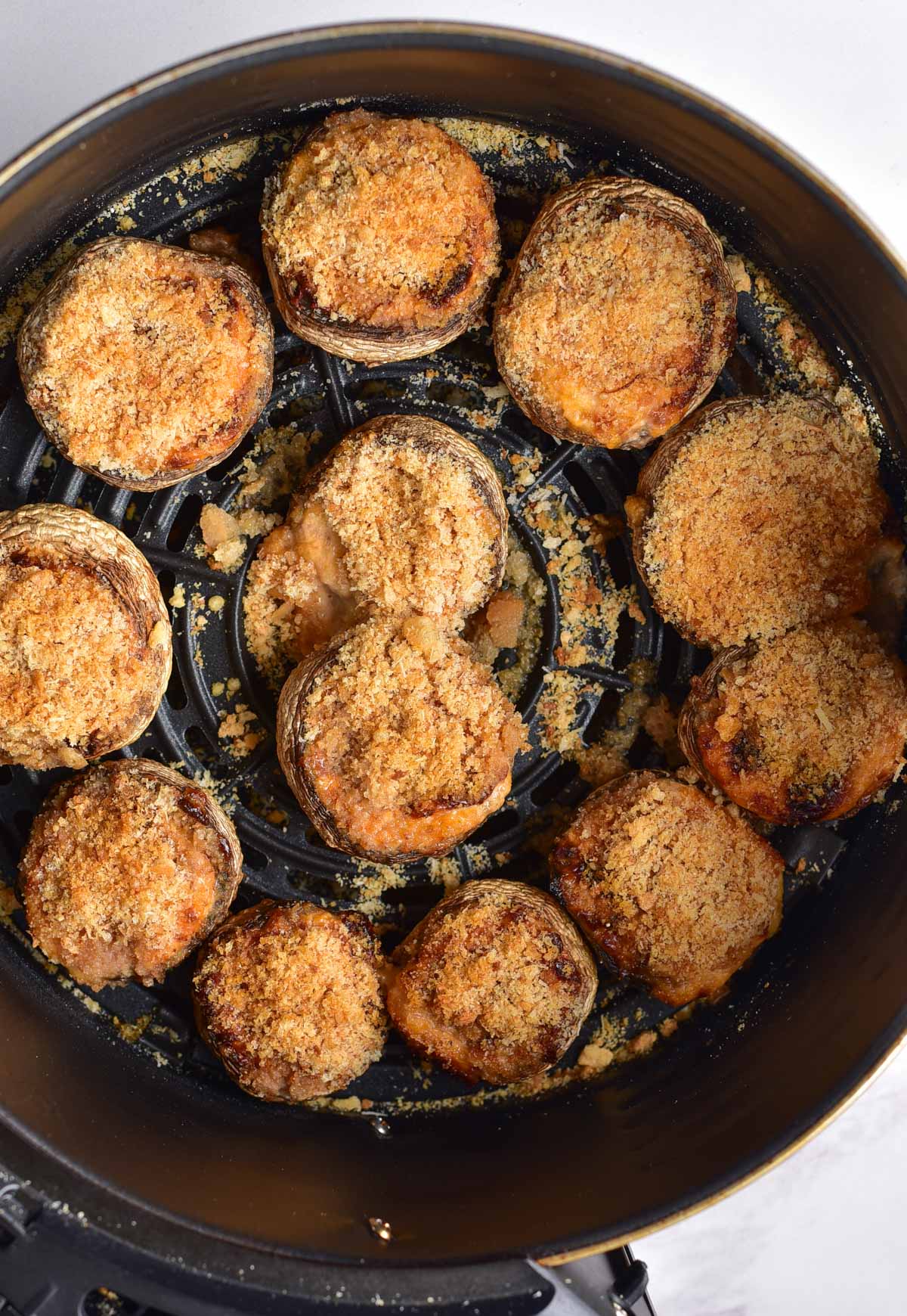 top down view of the finished stuffed mushrooms in air fryer basket
