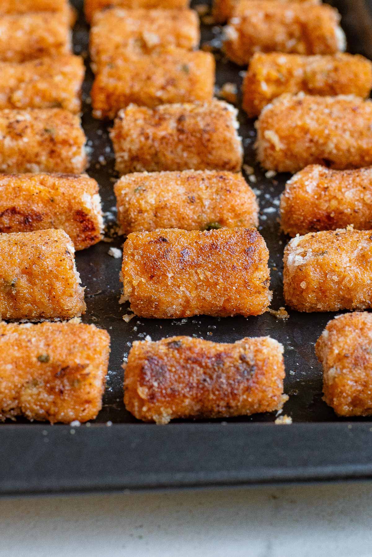 close up view of the cooked sweet potato tater tots on a baking sheet