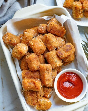 sweet potato tater tots in a baking dish with a side of ketchup