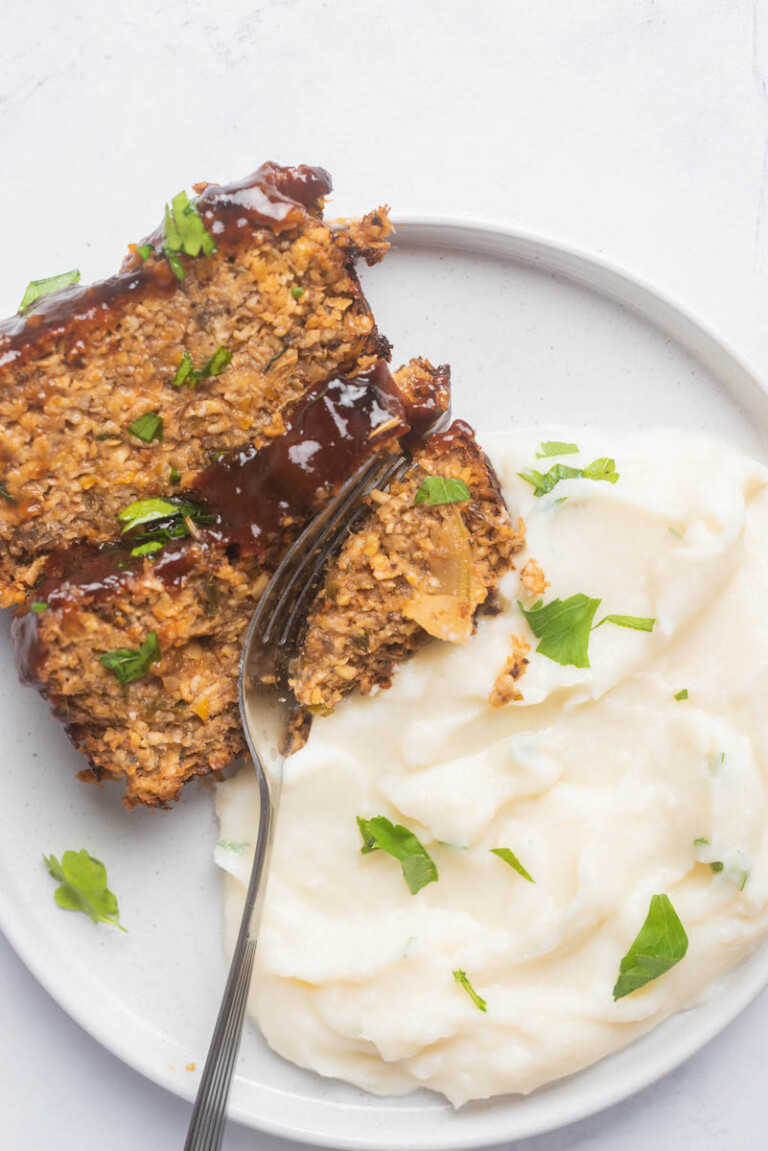 top down view of a serving of vegan meatloaf with a side of mashed potatoes