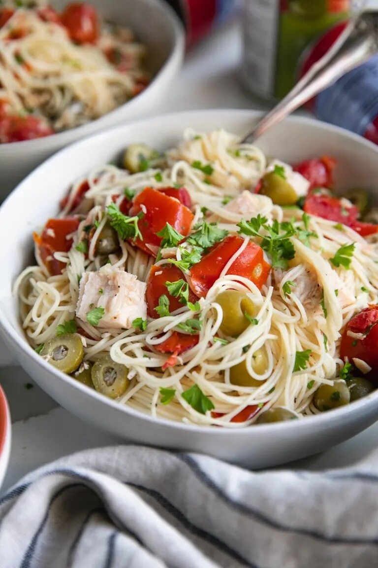 a white bowl filled with angel hair pasta with chicken