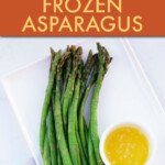 Cooked asparagus on a square plate with a side dish of melted butter