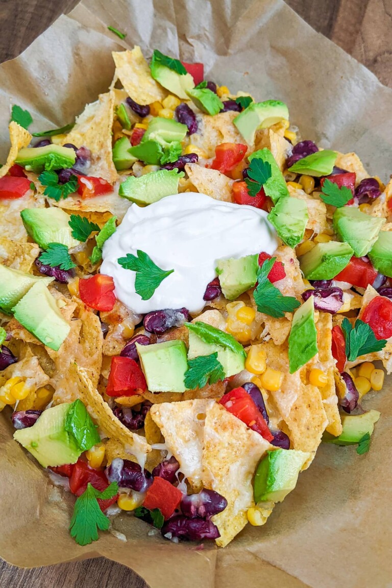 Close up image of Cheesy Air Fryer Nachos on brown paper.