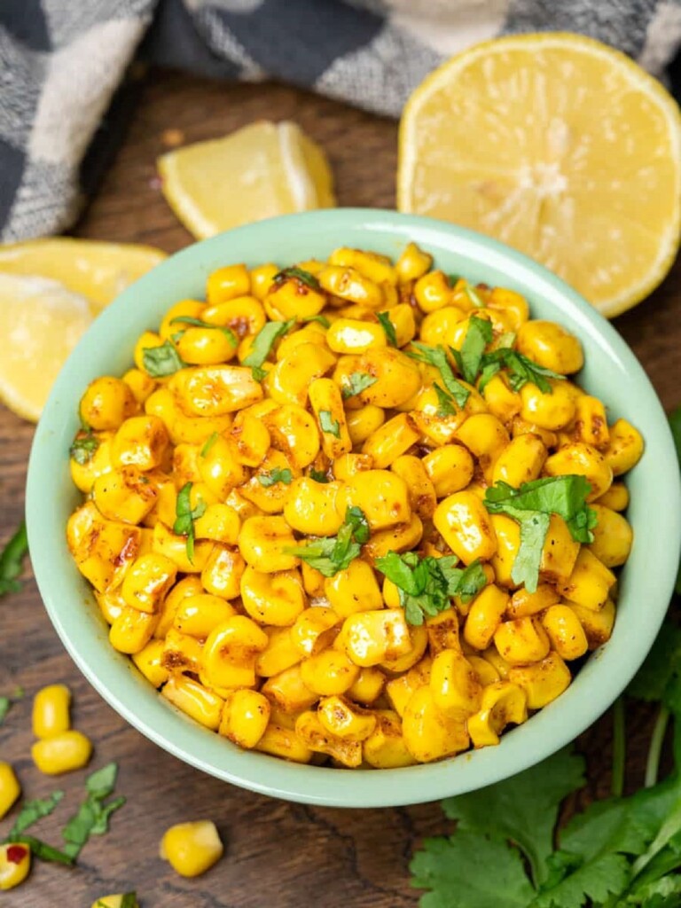 Masala corn in a blue serving bowl with garnish.