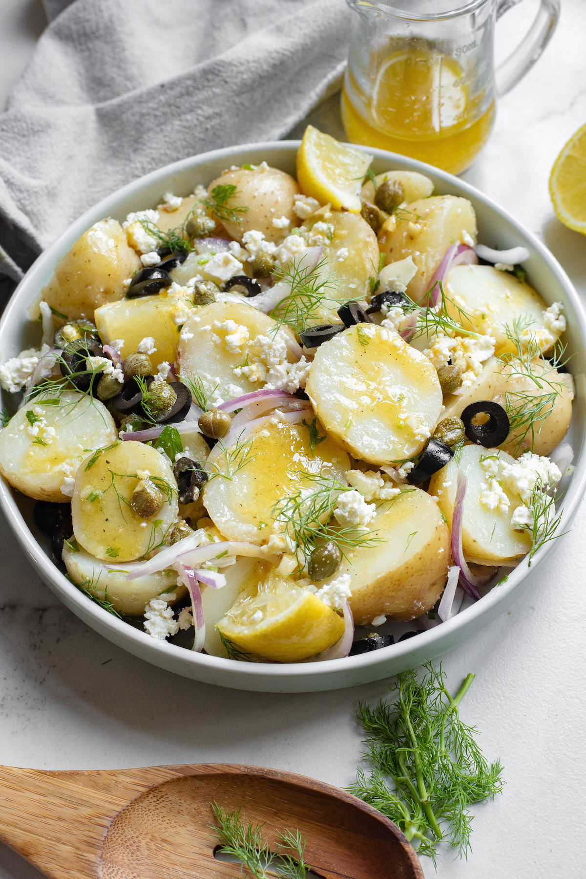 a large bowl of greek potato salad on a table