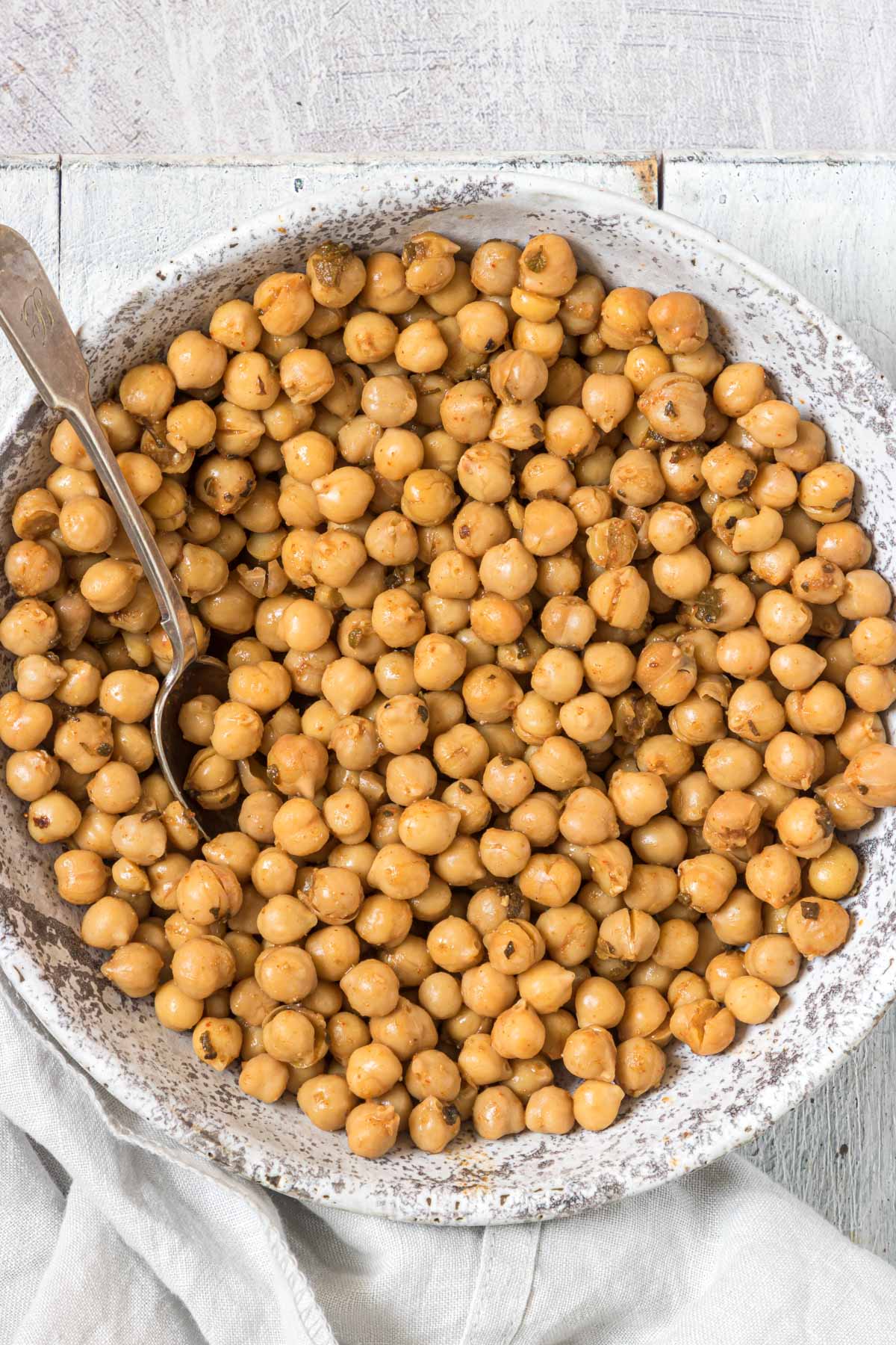 a bowl filled with the finished how to cook canned chickpeas and a large spoon