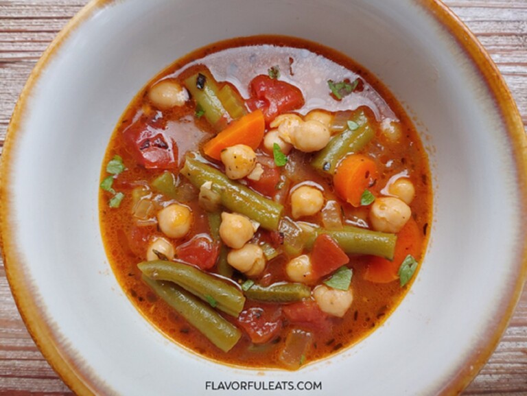Italian Chickpea Vegetable Soup in a white and brown rimmed soup bowl.