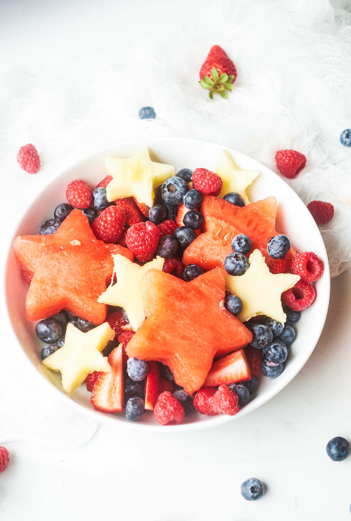 close up of a red white and blue fruit salad on a table