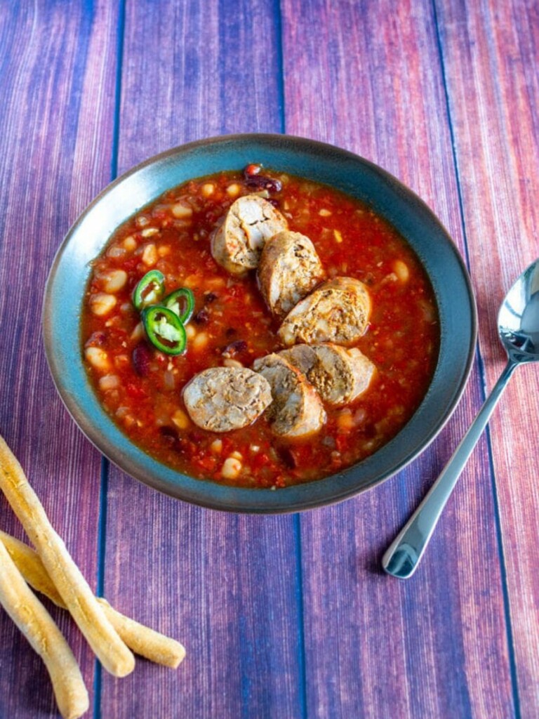 Sicilian Homemade Sausages with Beans Stew in a blue plate.