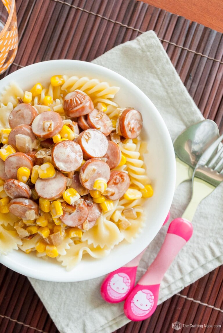 Turkey Sausage and Corn Kids Pasta in a white plate with pink kids knife and fork.