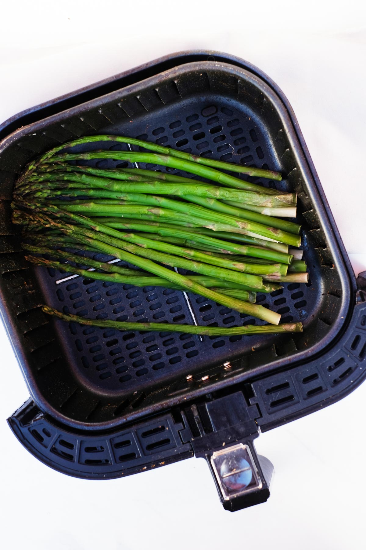 top down view of the cooked frozen asparagus in air fryer basket