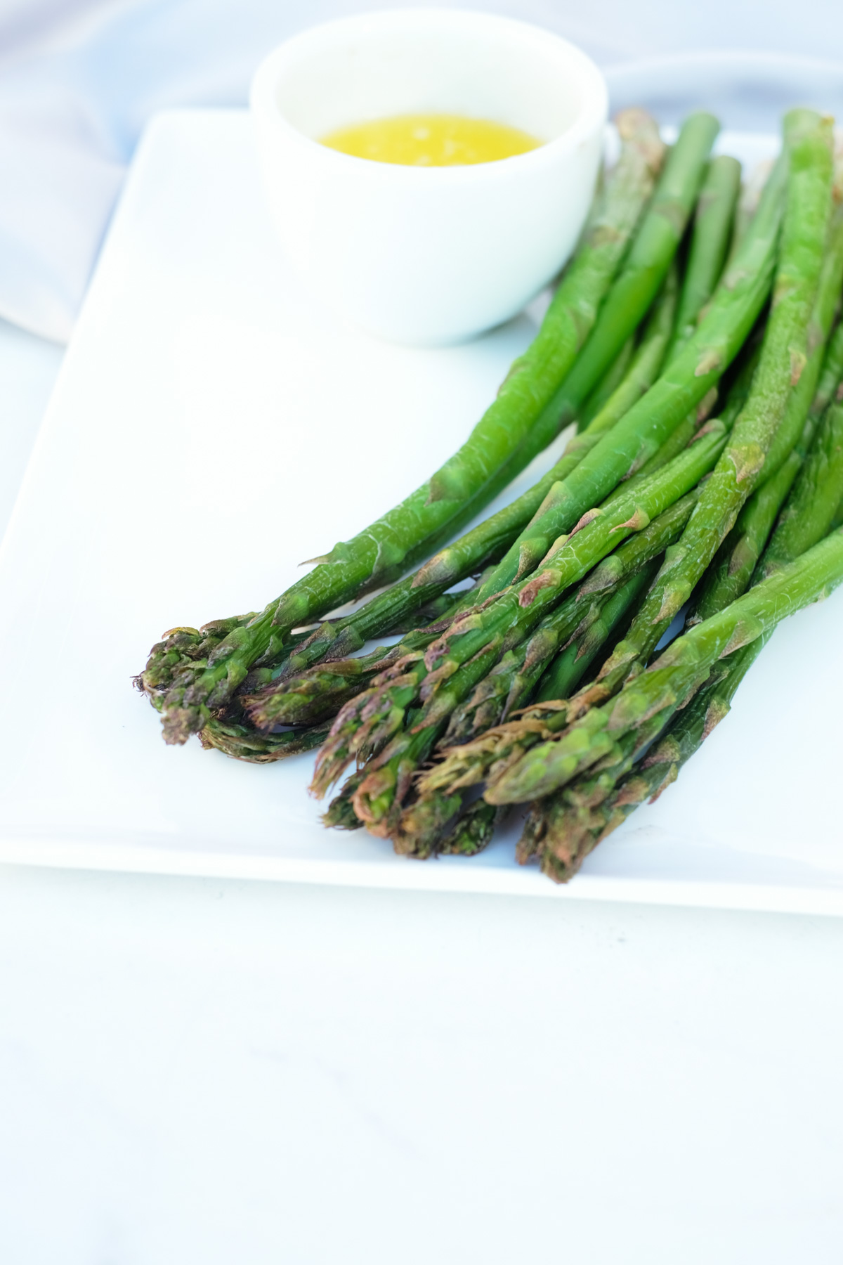 the completed frozen asparagus in air fryer recipe served on a white plate