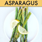 cooked asparagus on a plate garnished with lemon slices.