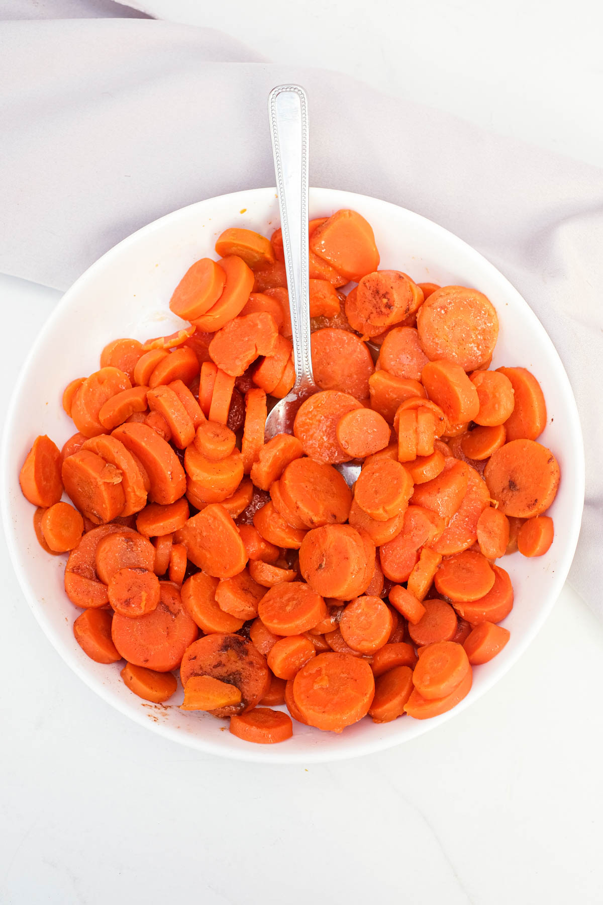 a serving spoon inside a bowl filled with the finished how to cook canned carrots recipe