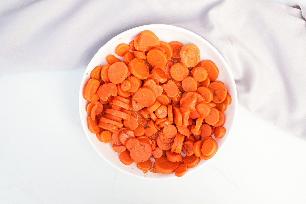 a white bowl filled with the completed how to cook canned carrots