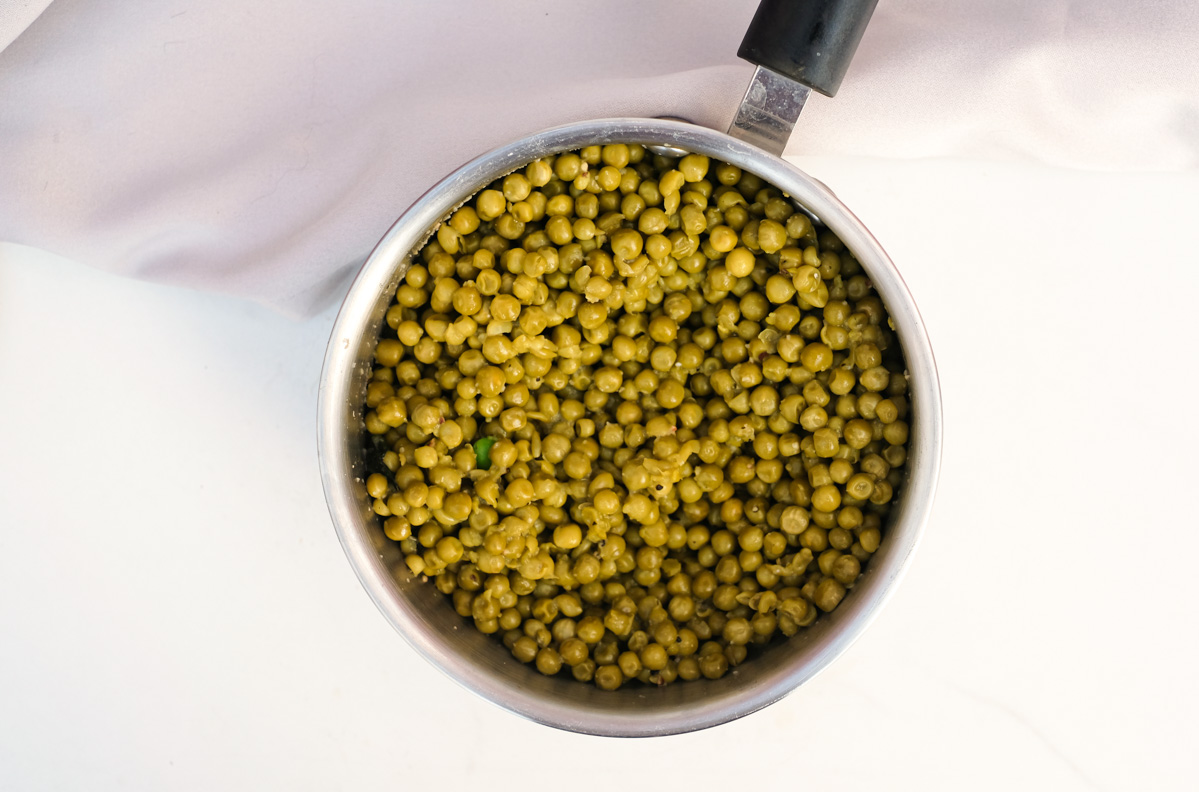 top down view of the cooked canned peas in a saucepan