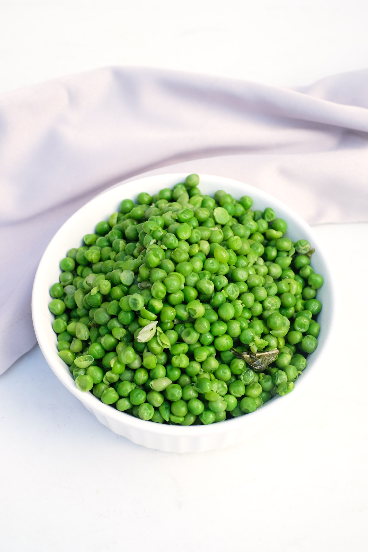 top down view of the finished how to cook frozen peas in a white dish