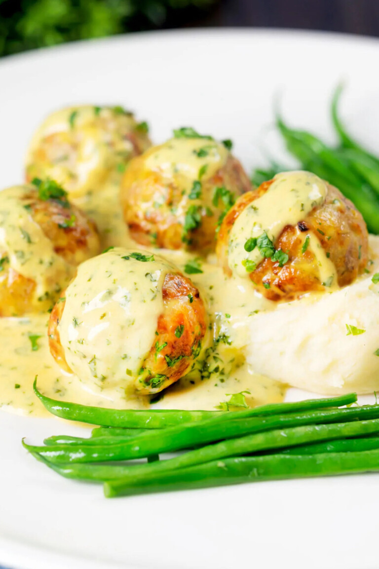the finished chicken meatballs with honey mustard sauce served with green beans and potatoes