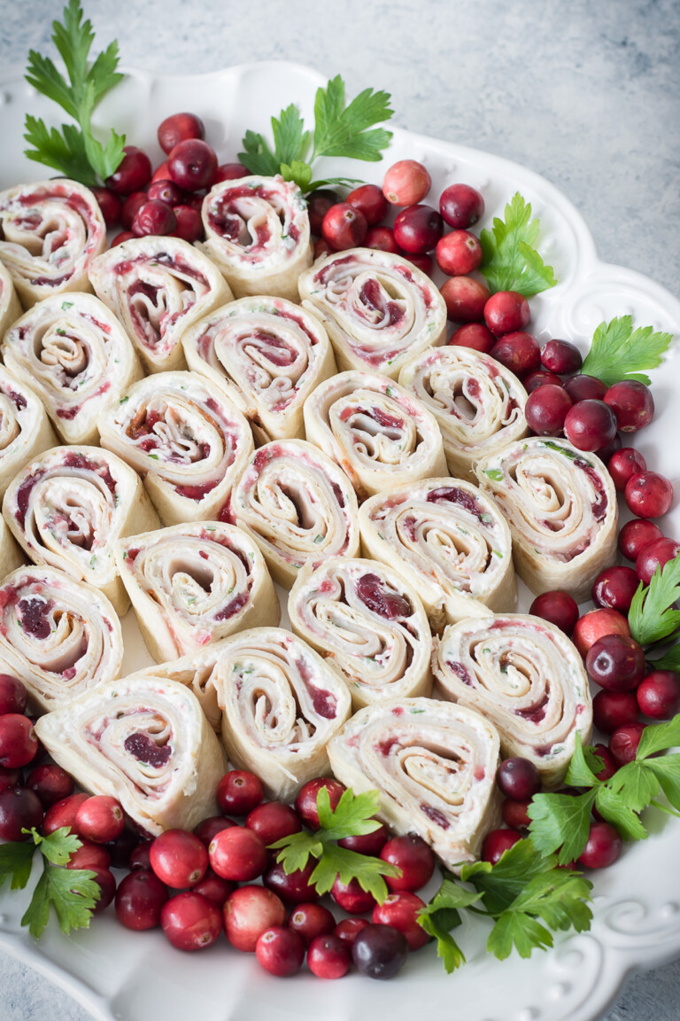 a serving platter filled with cranberry turkey pinwheels