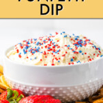 side view of a bowl of funfetti dip on a plate with strawberries and pretzels