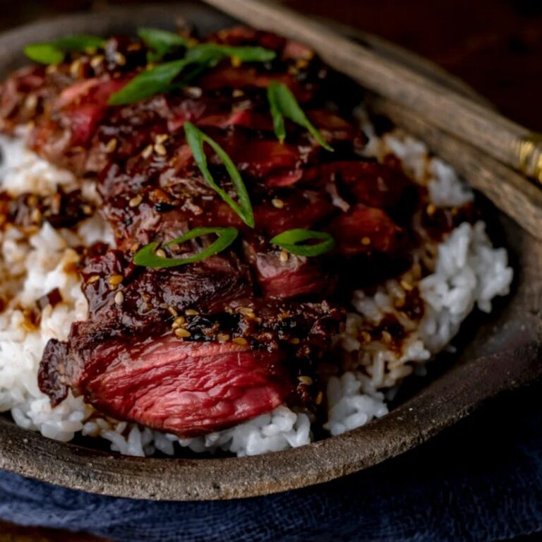 Grilled Elk Steak with Asian Marinade in a wooden bowl with chopsticks.
