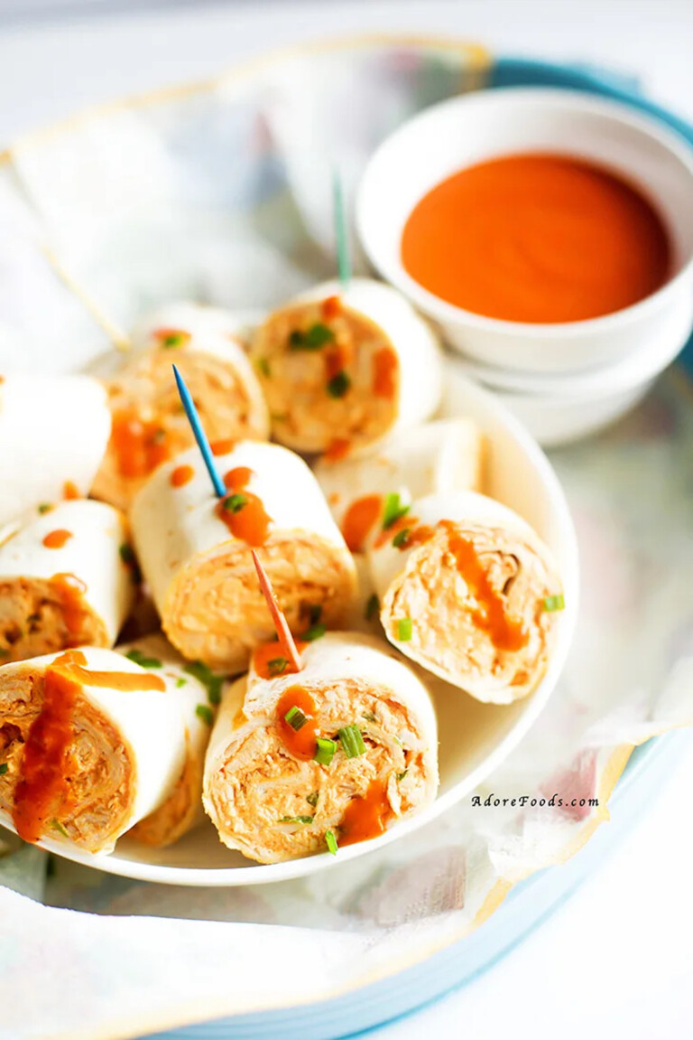 Buffalo Chicken Pinwheels served with toothpicks and a cup of buffalo sauce