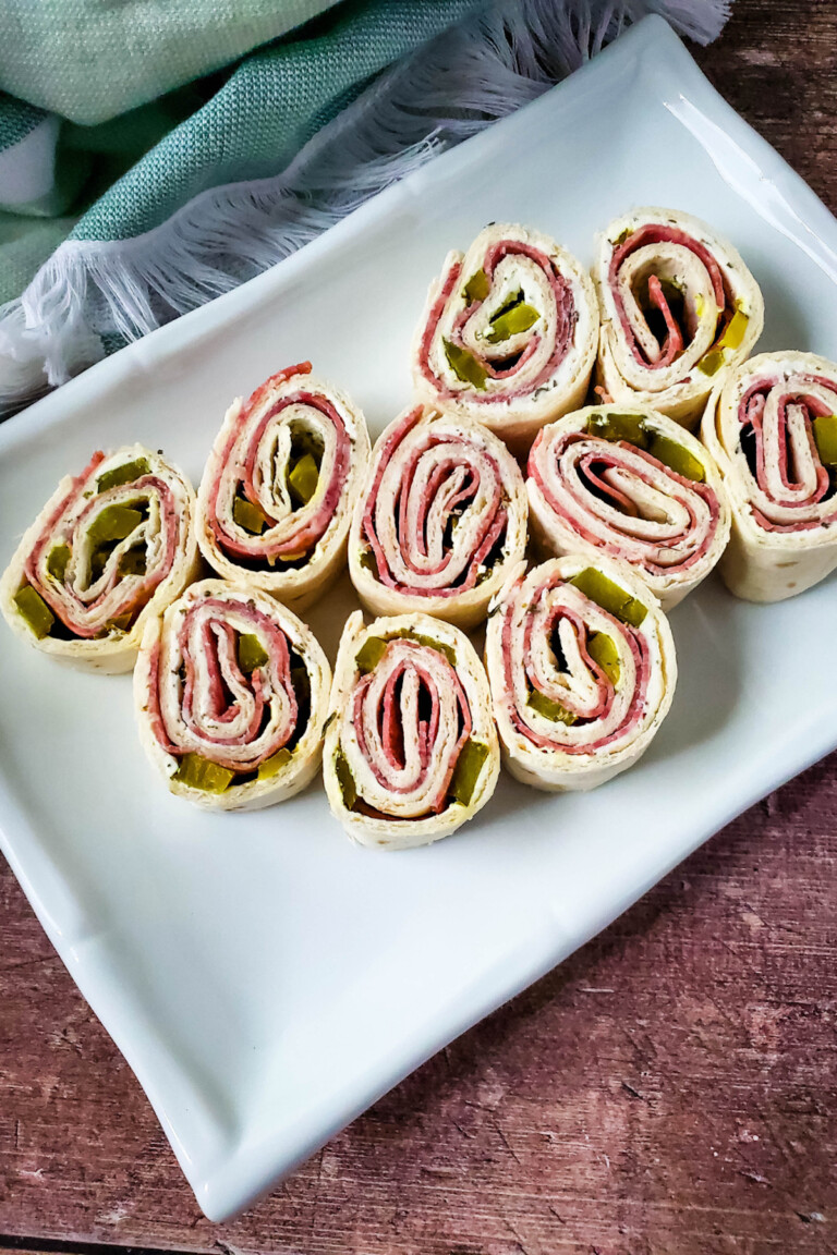 top down view of salami cream cheese pinwheels on a white platter