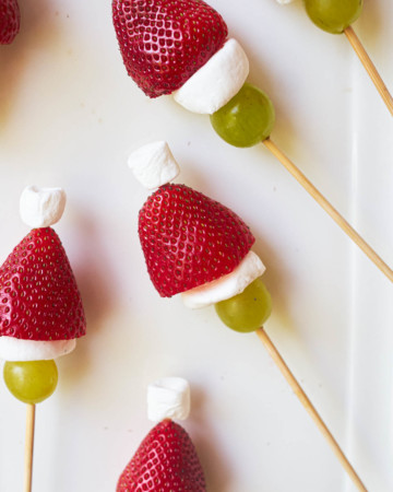 A plate ful of colorful grinch kabobs in skewers