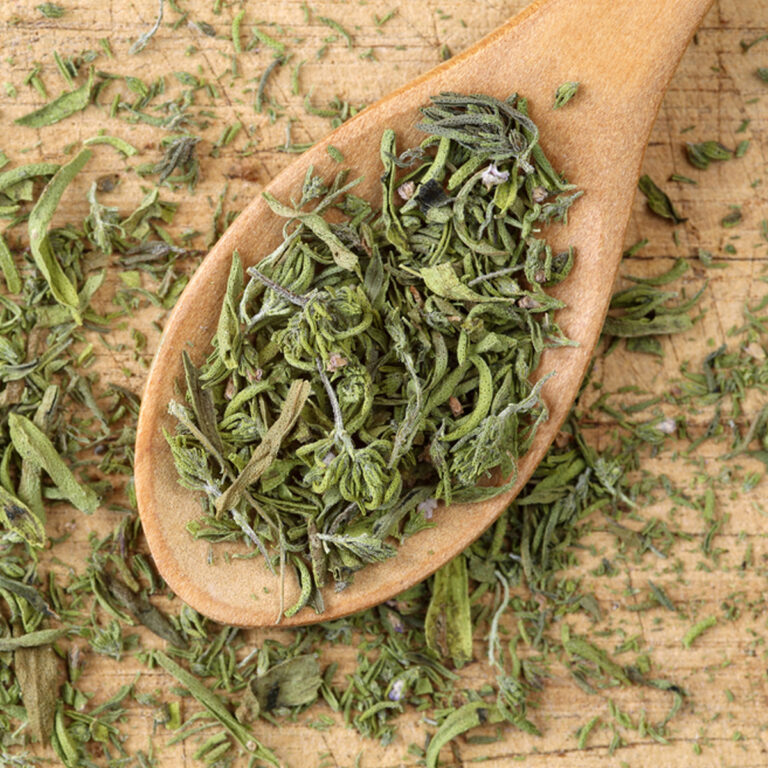A wooden spoon full of dried summer savory