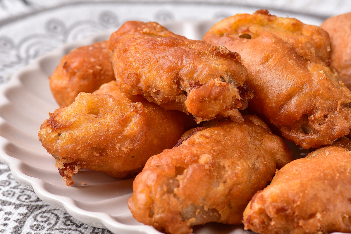 close up view of deep fried chicken wings on a white plate