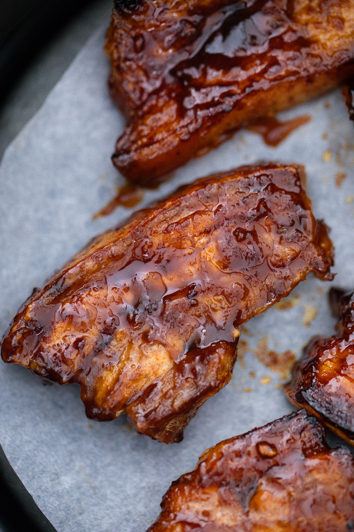 Close up view of Air Fryer Pork Belly on parchment paper in Air Fryer.