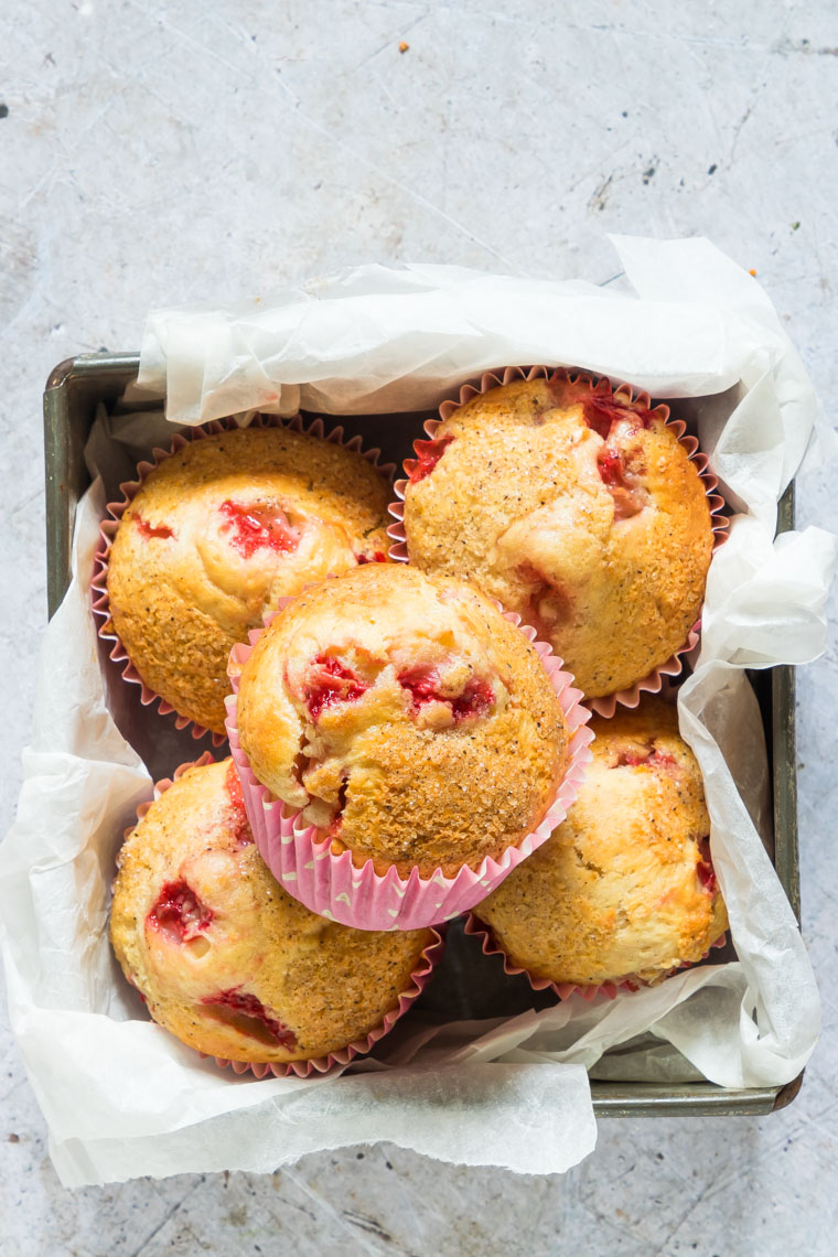 five strawberry muffins packaged in a square baking tin