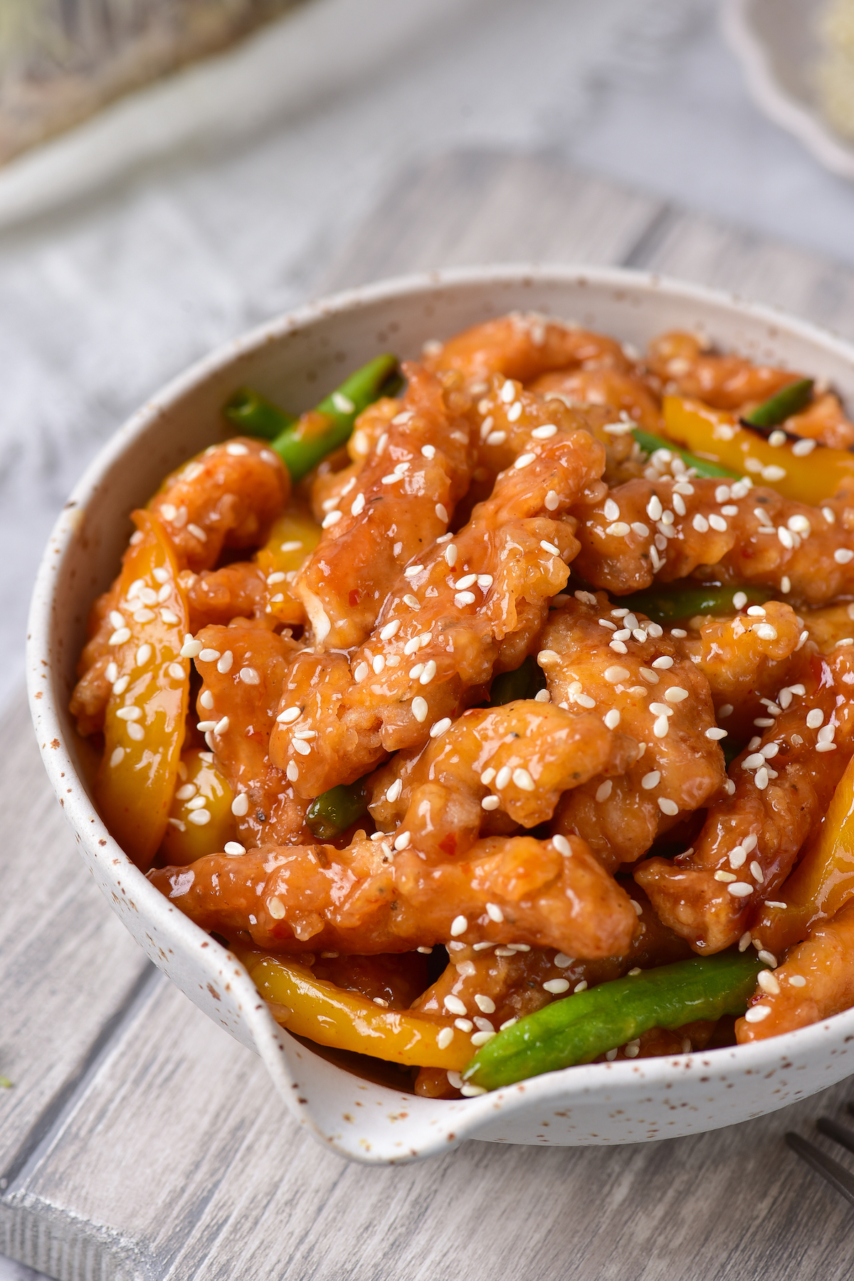 one serving of honey sesame chicken in a white bowl
