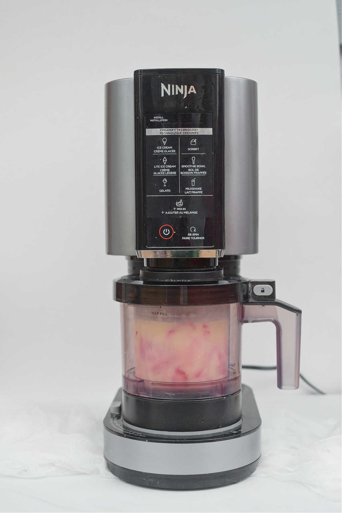 the frozen strawberry ice cream base being processed in the Ninja Creami machine