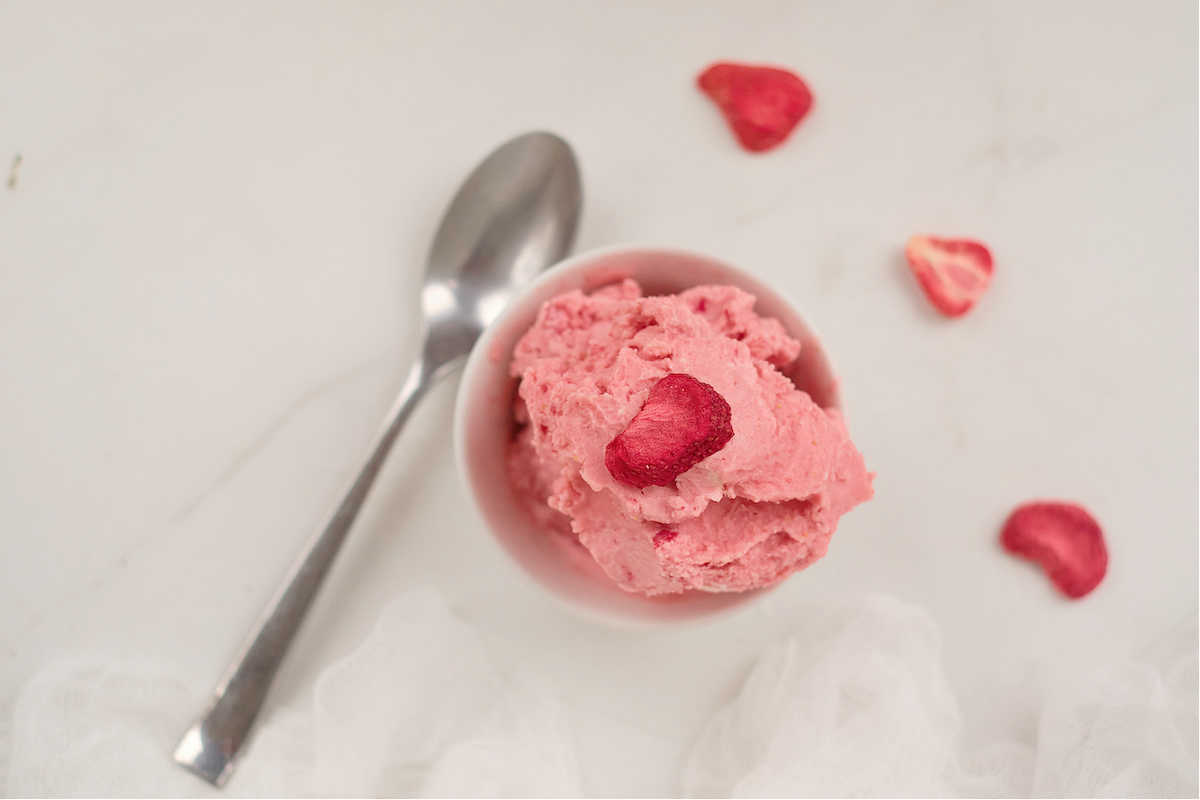 top down view of a dish of strawberry ice cream with freeze dried strawberry slices