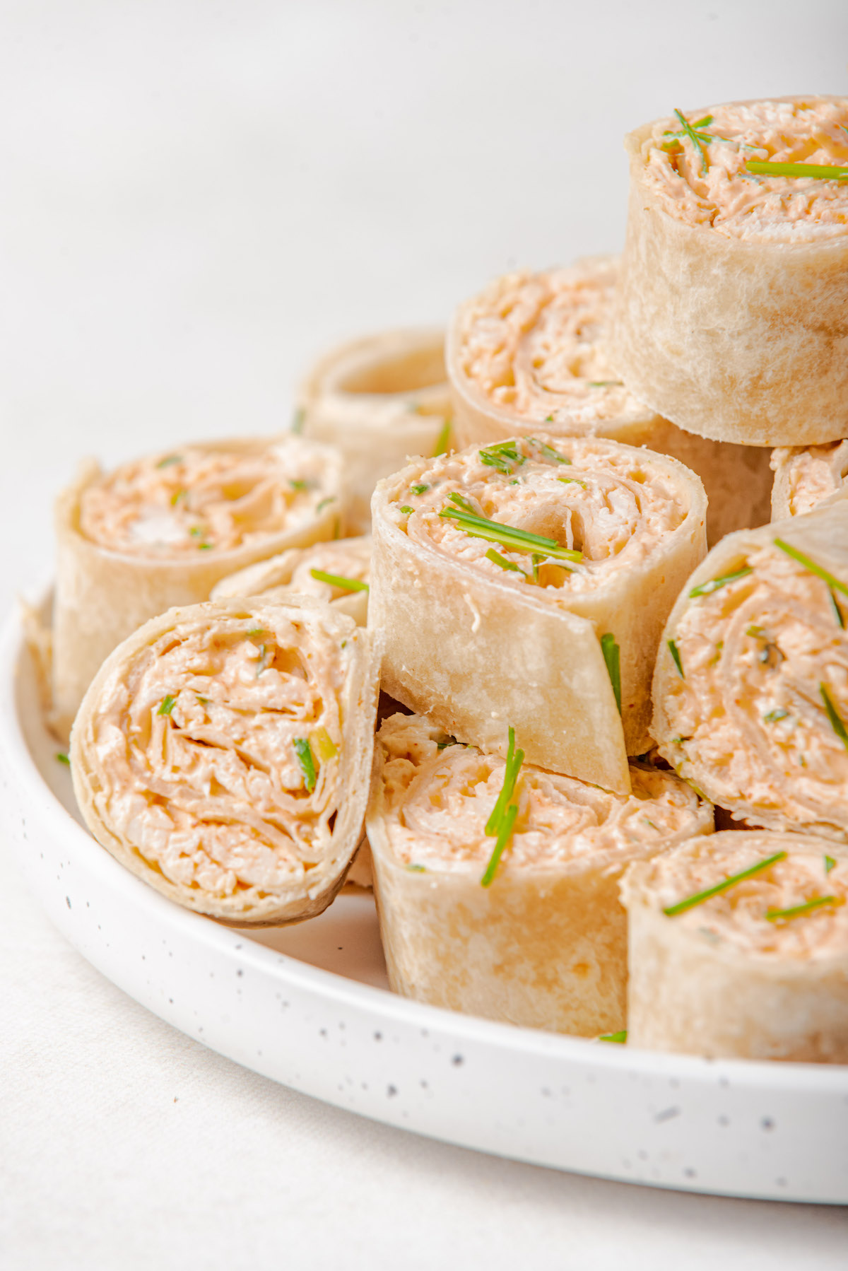 a white plate filled with buffalo chicken dip pinwheels