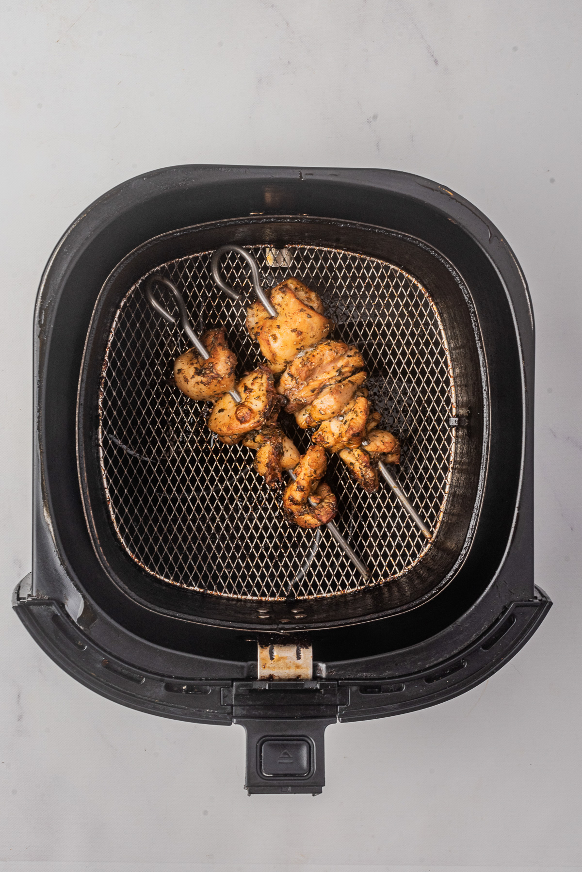 Cooked Air Fryer Greek Chicken in the air fryer basket