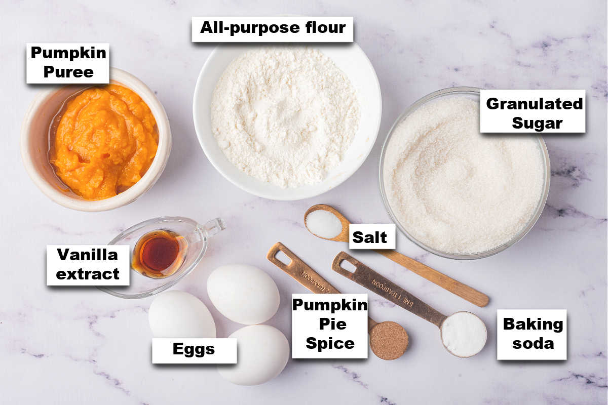 Ingredients for a pumpkin roll recipe laid out on a marble surface.