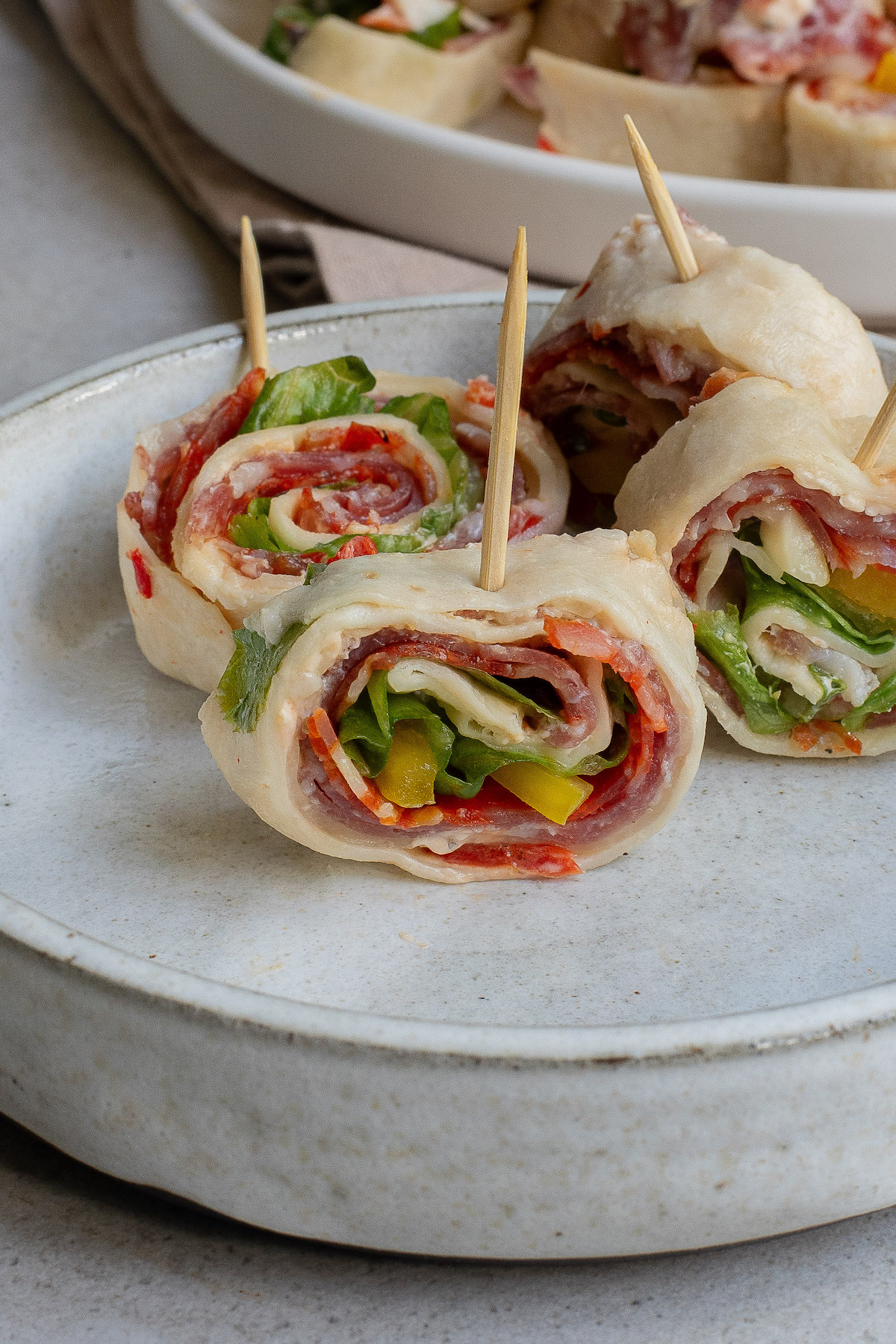 close up of 4 Italian sandwich pinwheel pieces on a plate