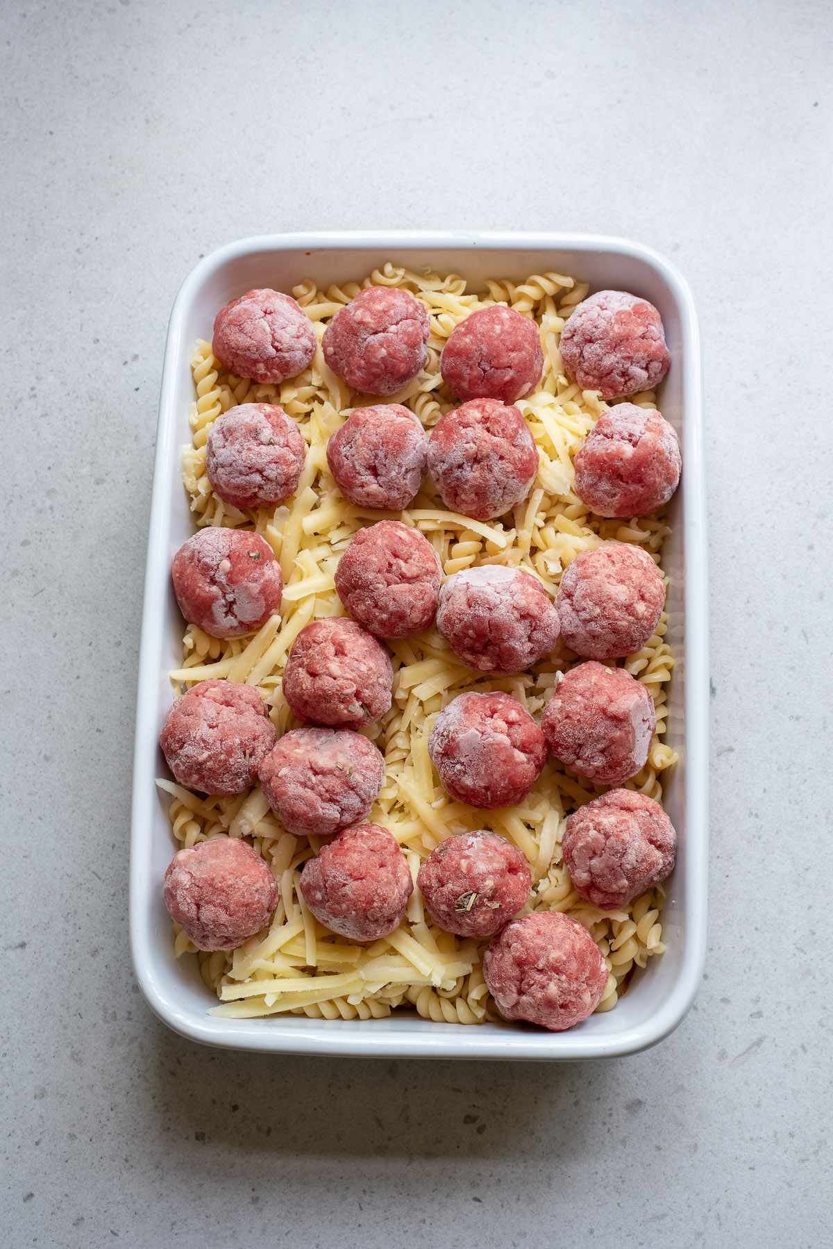 the uncooked casserole with the frozen meatballs added