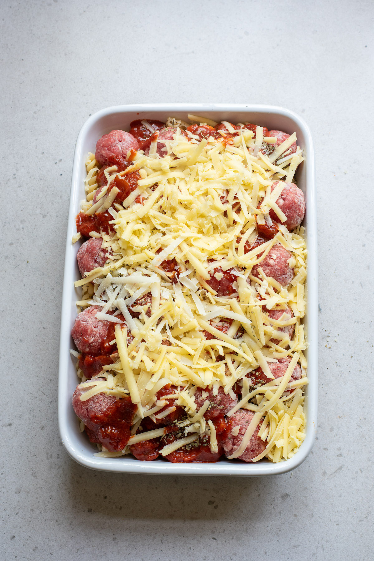 the casserole topped with cheese and ready to be baked
