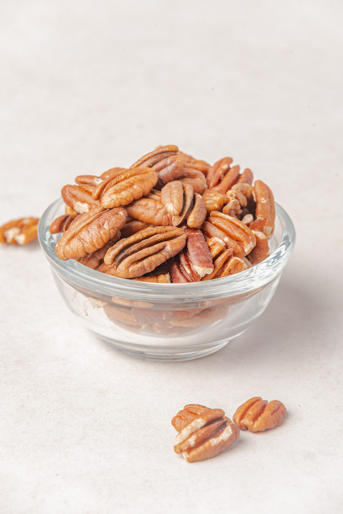 a glass bowl filled with the completed roast pecans