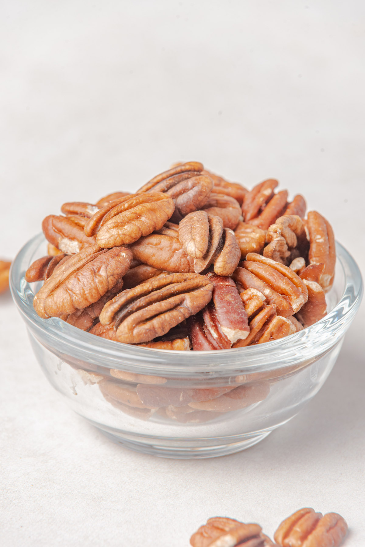 a glass bowl filled with pecan halves