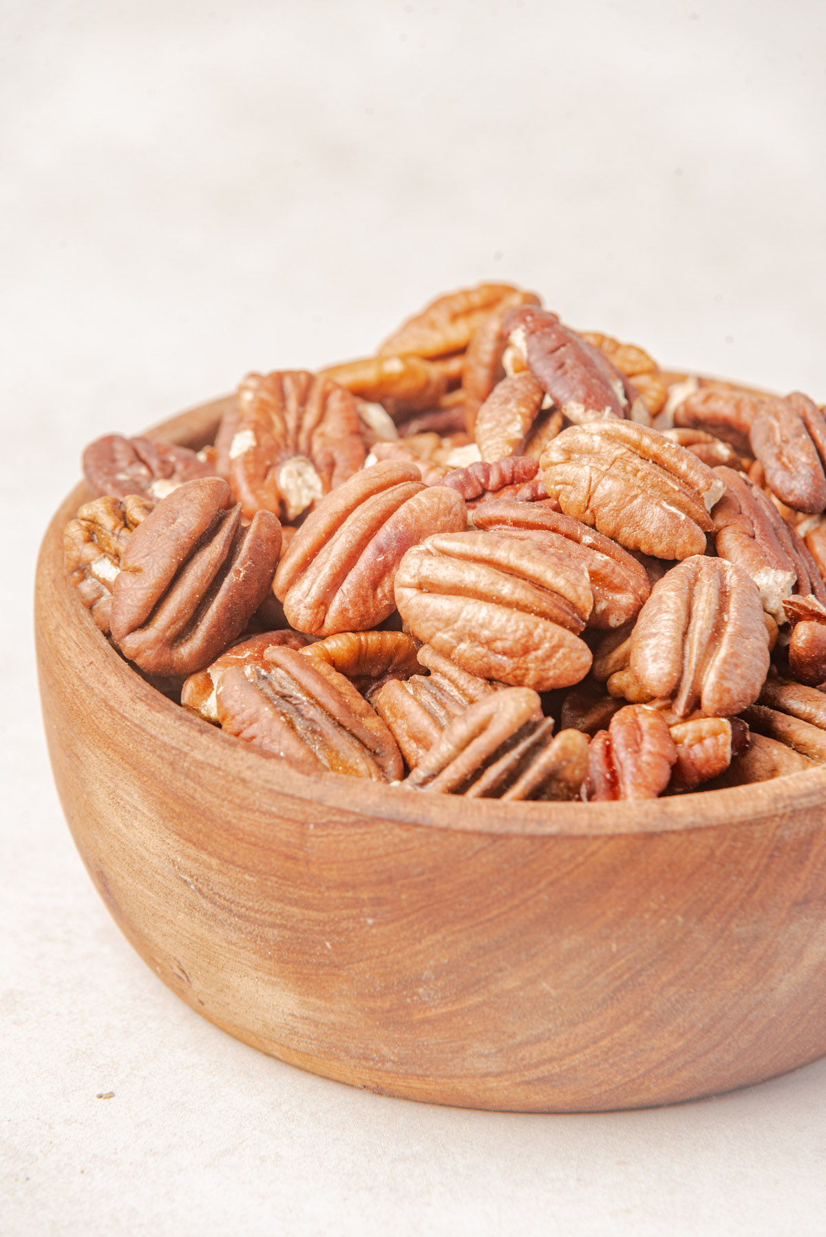 a wooden bowl filled with pecans