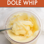 A spoon scooping dole whip out of a jar