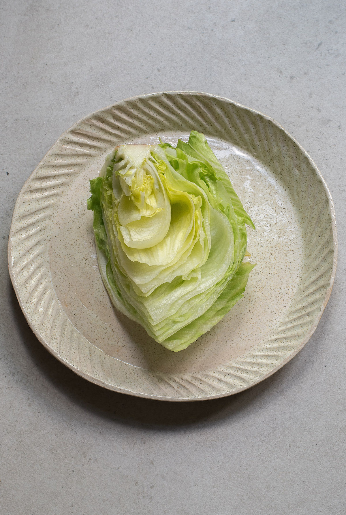 one wedge of iceberg lettuce on a serving plate