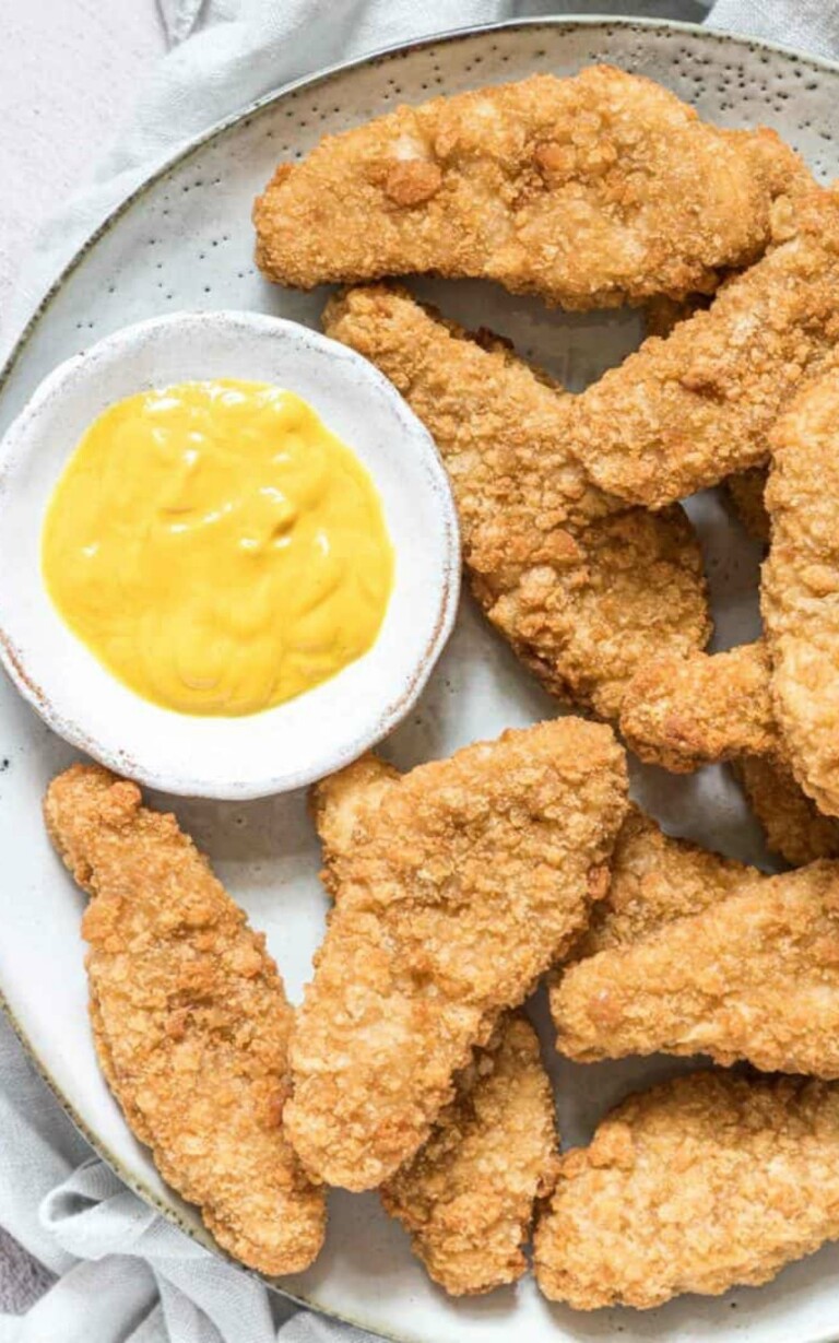 Chicken Tenders In Air Fryer in a white plate served with mustard.