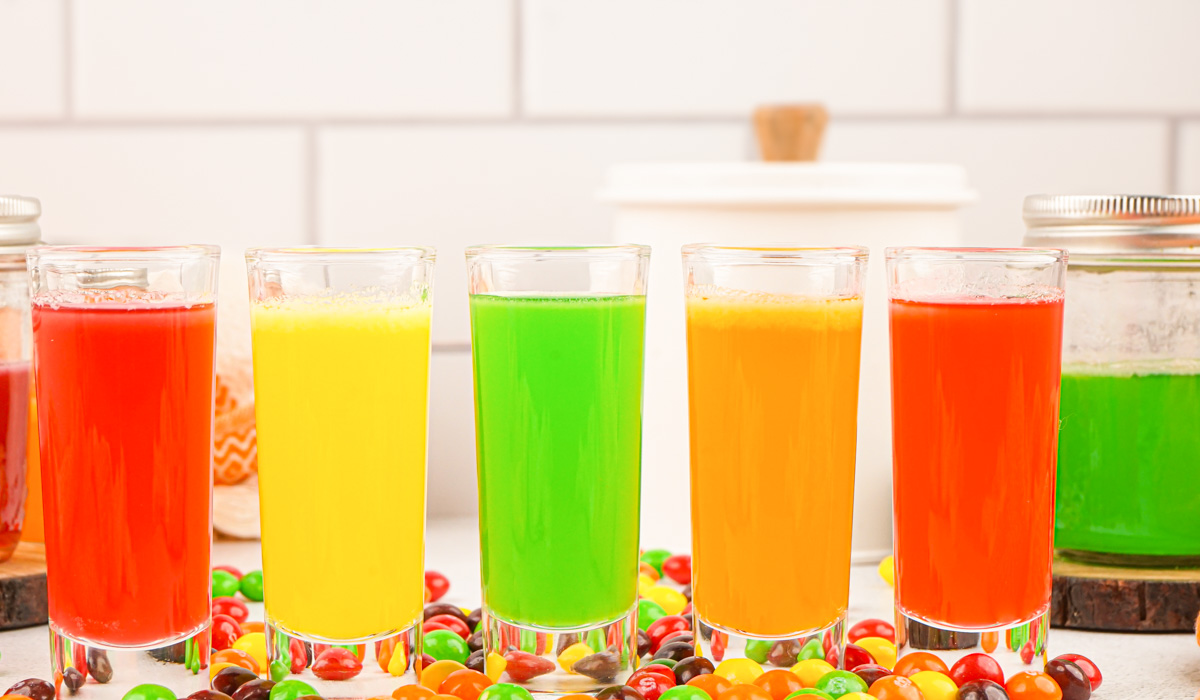 a row of all 5 colors of Skittles shots in glasses