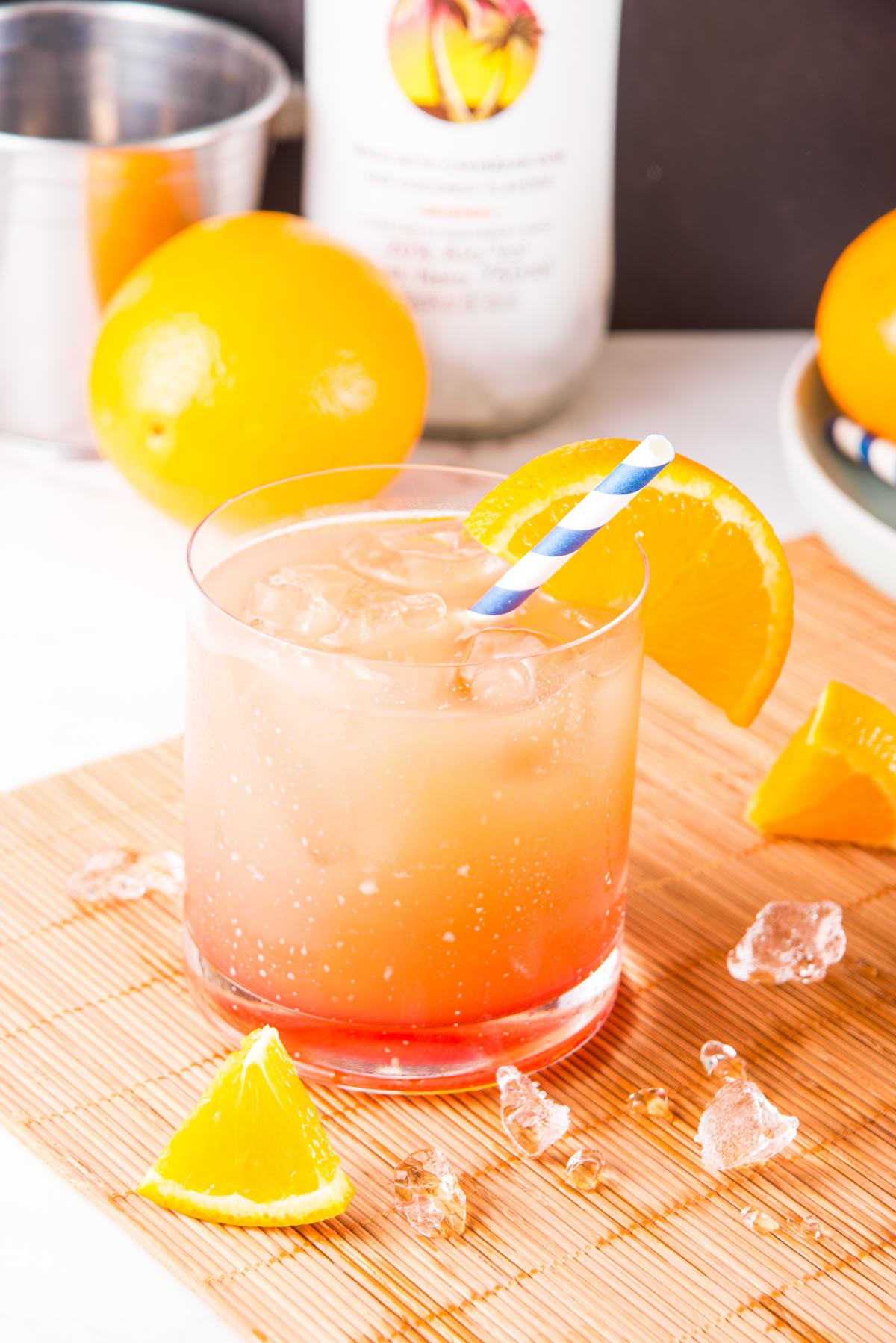 a bahama mama cocktail surrounded by oranges and ice cubes